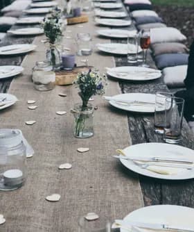 Long rustic banquet table set with wildflowers and place settings