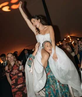 Bride lifted on a friend’s shoulders on the dance floor